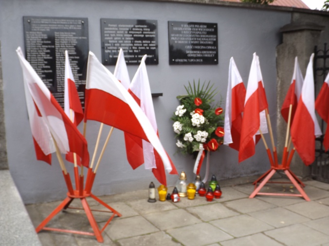 Znicze i wieniec pod tablicą upamiętniającą marturologię Kresowian na cmentarzu parafialnym w Oświęcimiu, 12 lipca 2014 r. Fot. Bohdan Piętka